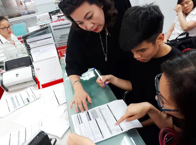 Không chỉ hỗ trợ các bệnh nhân nghèo, nhóm “Táo y tế” còn chia sẻ với những hoàn cảnh kém may mắn khác trong xã hội. Trong ảnh, nhà báo Hoài Thu (Truyền hình Nhân dân) đưa em Đức Anh, con trai lớn của chị Lê Thị Thu Hà -người lao công tử vong trong vụ tai nạn thảm khốc ở đường Láng, Hà Nội (tháng 4/2019), ra ngân hàng lập sổ tiết kiệm. Số tiền này được huy động từ nguồn ủng hộ tiền mặt và lãi bán hàng từ thiện.