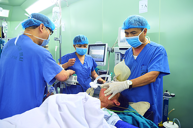 Bác sĩ Hào đang bóp bóng để cung cấp oxy cho bệnh nhân nữ bị K dạ dày. Ảnh: Giang Huy