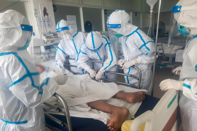 Các nhân viên y tế chăm sóc cho một bệnh nhân tại Bệnh viện Dã chiến Hoà Vang. Ảnh: Đông Phương.