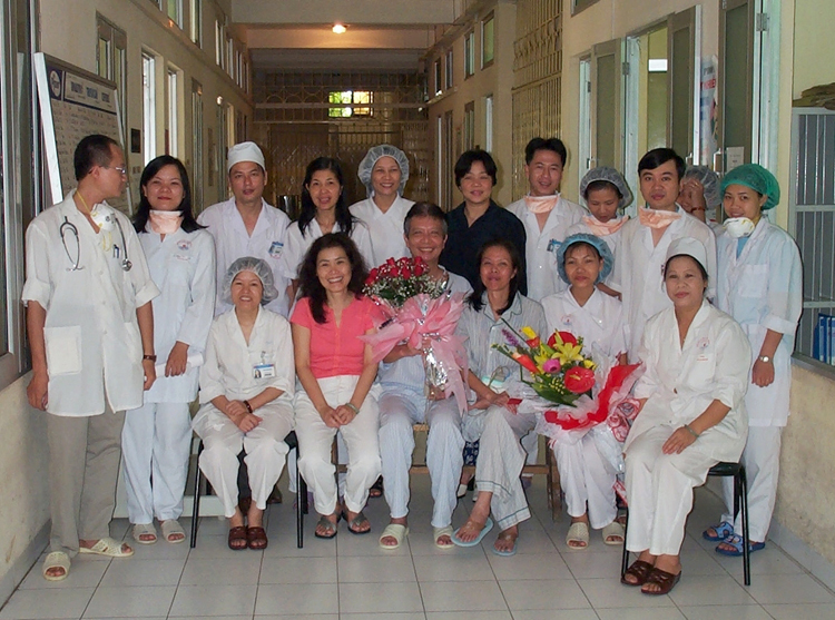 Y tá Nguyễn Thị Thục (người đầu tiên bên phải) cùng các đồng nghiệp chụp hình lưu niệm với bệnh nhân Sars, ông Hùng (ôm hoa hồng). Ảnh: Nhân vật cung cấp.